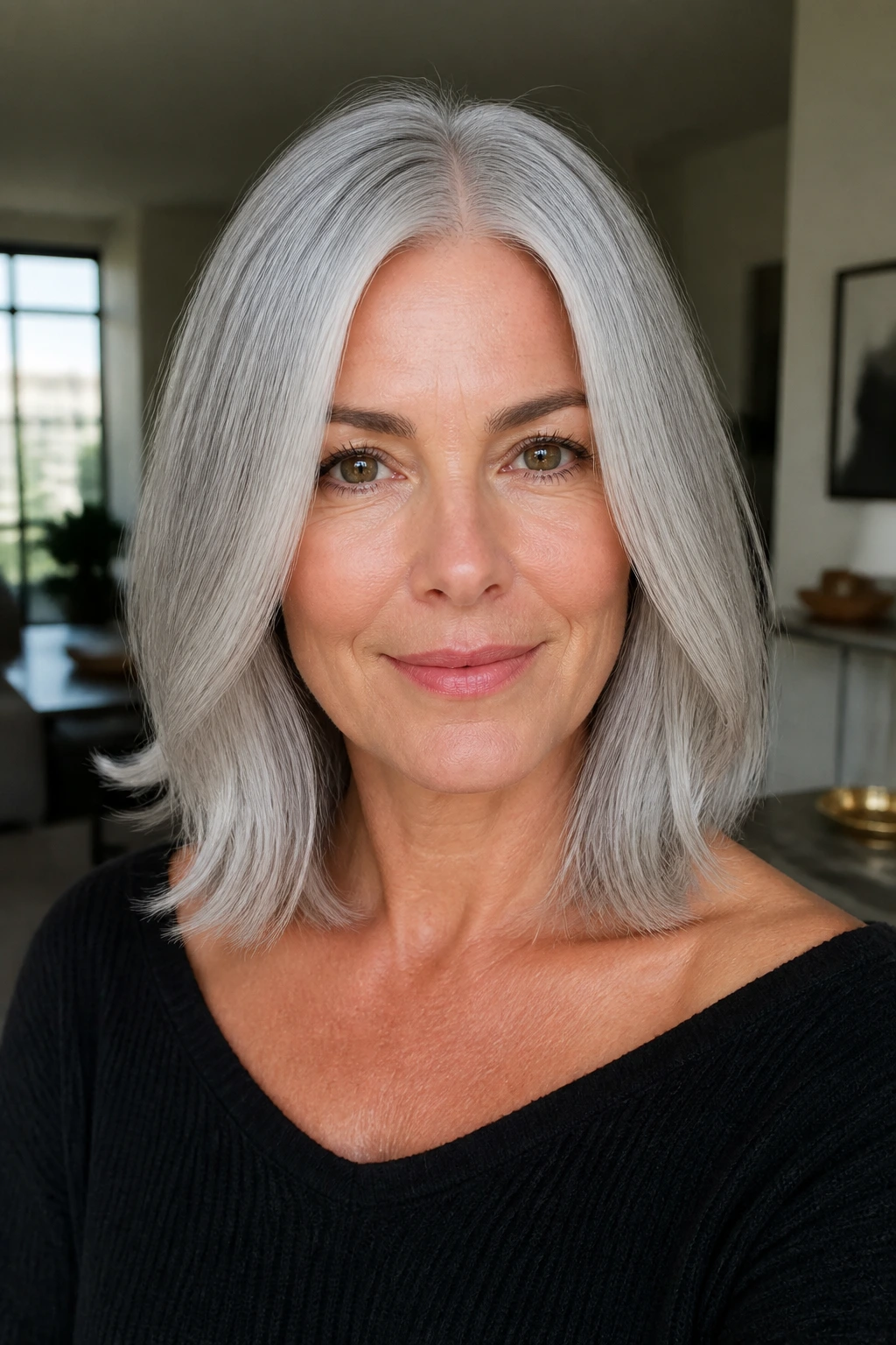 Close-up of a woman with a center-parted soft silver lob and collarbone-length hair in daylight.