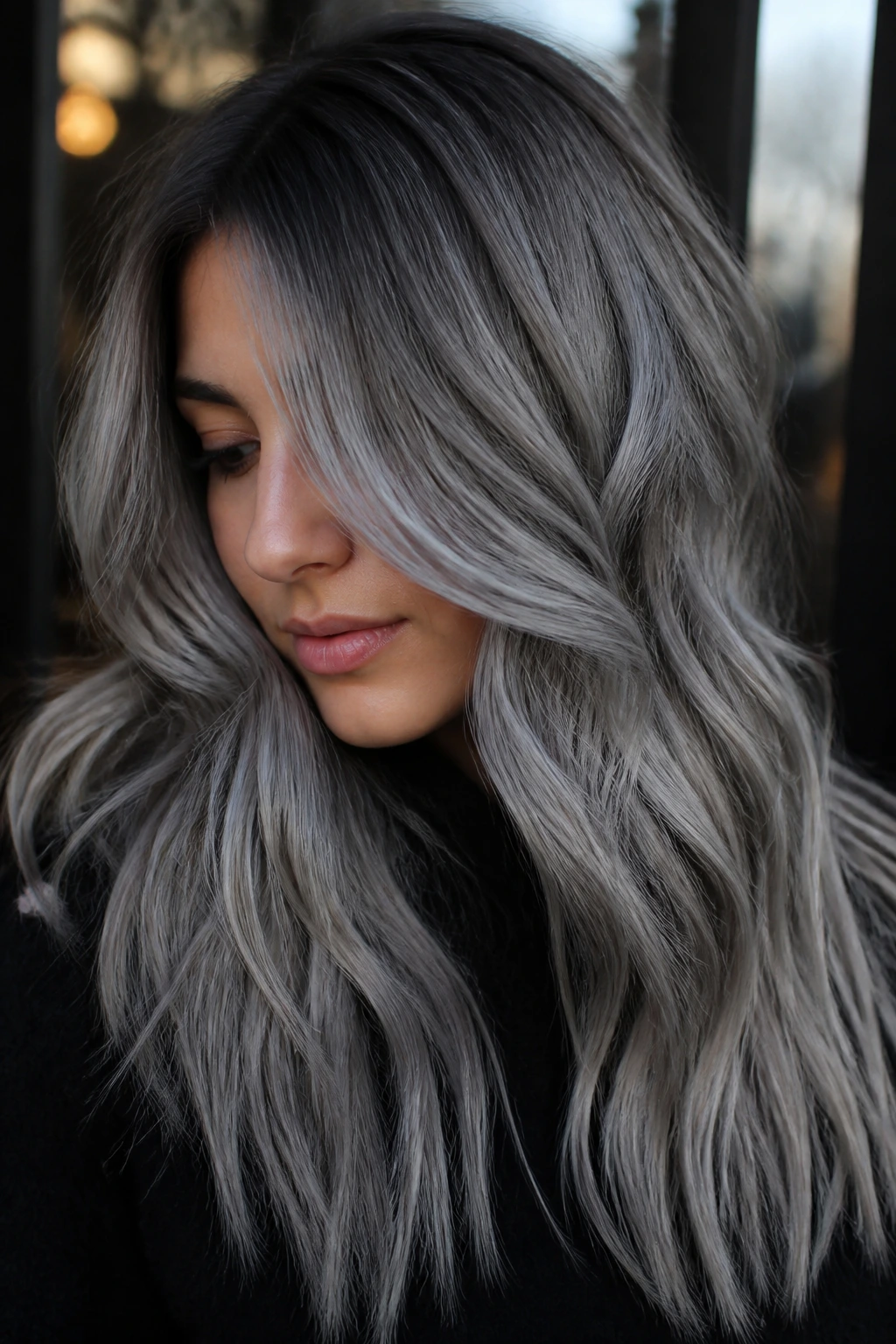 Real woman with cool silver smoke balayage in moody light