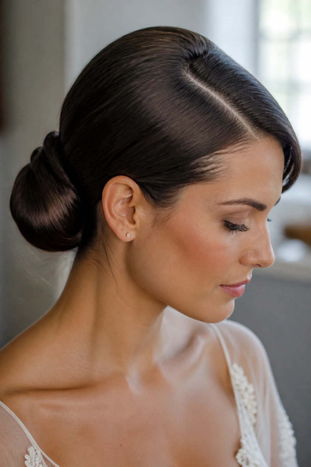Close-up of a real bride with a sleek low bun and deep side part
