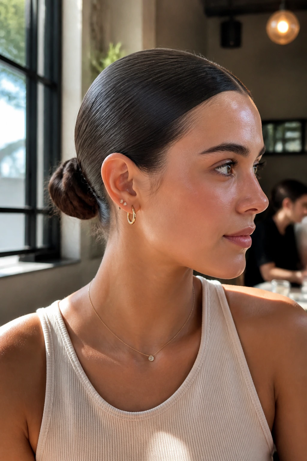 Close-up portrait of a woman with a sleek middle-part bun