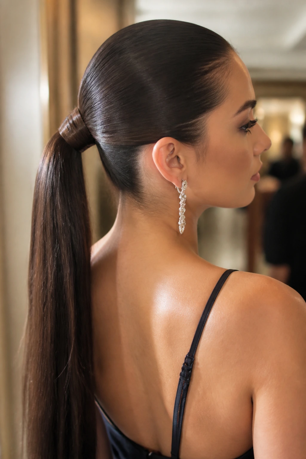 Close-up of a real woman with a sleek wrapped ponytail, polished evening look