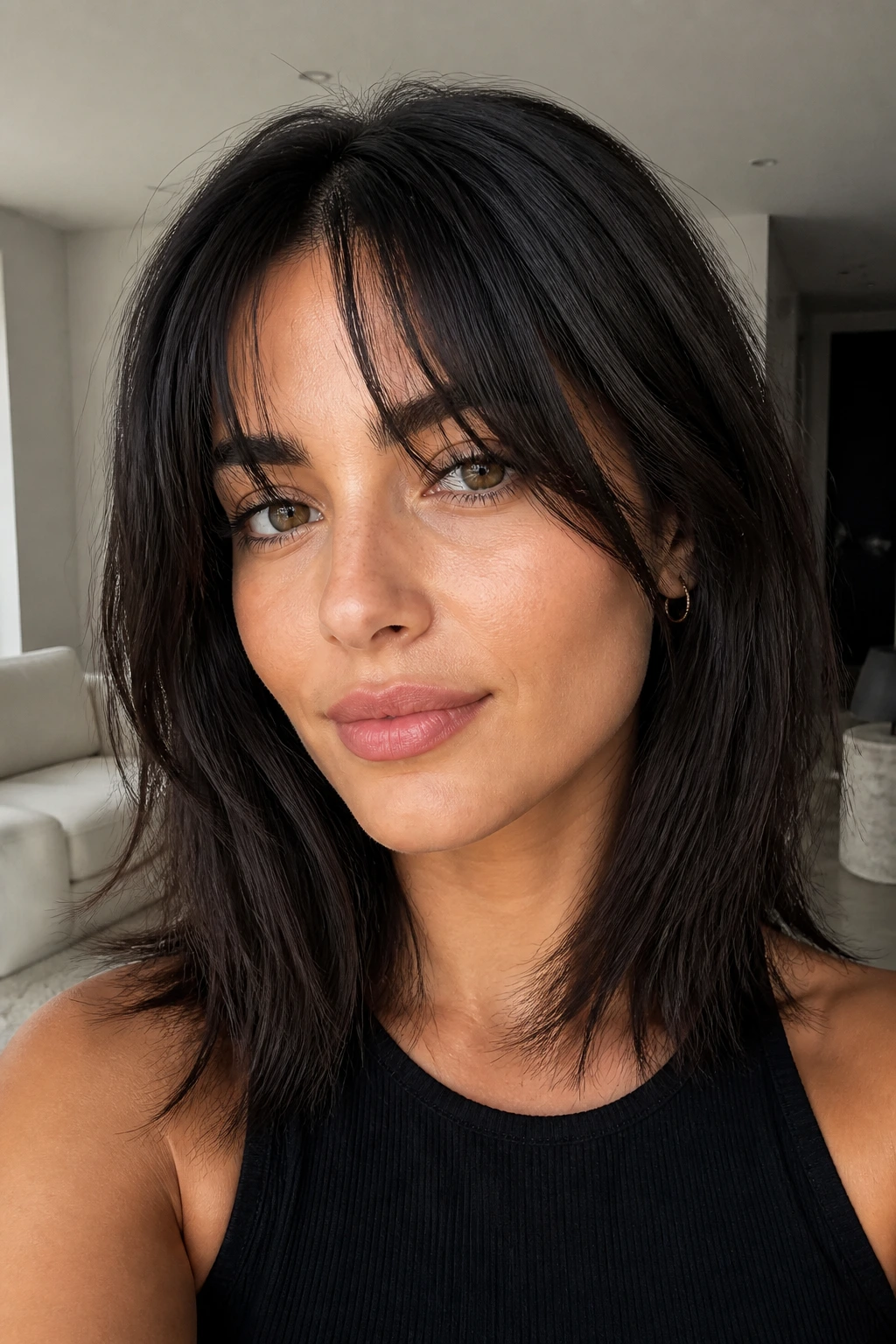 Close-up of a real woman with sliced fringe in a minimalist living room setting.