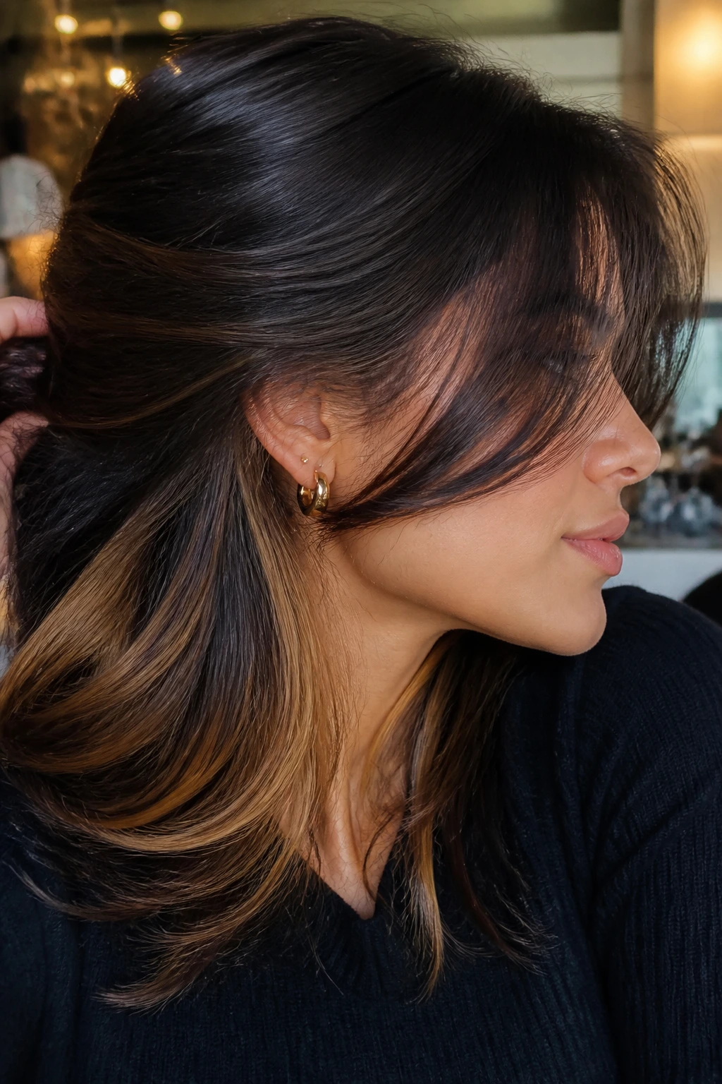 Side-profile of a woman with smoky brunette hair and hidden caramel panels
