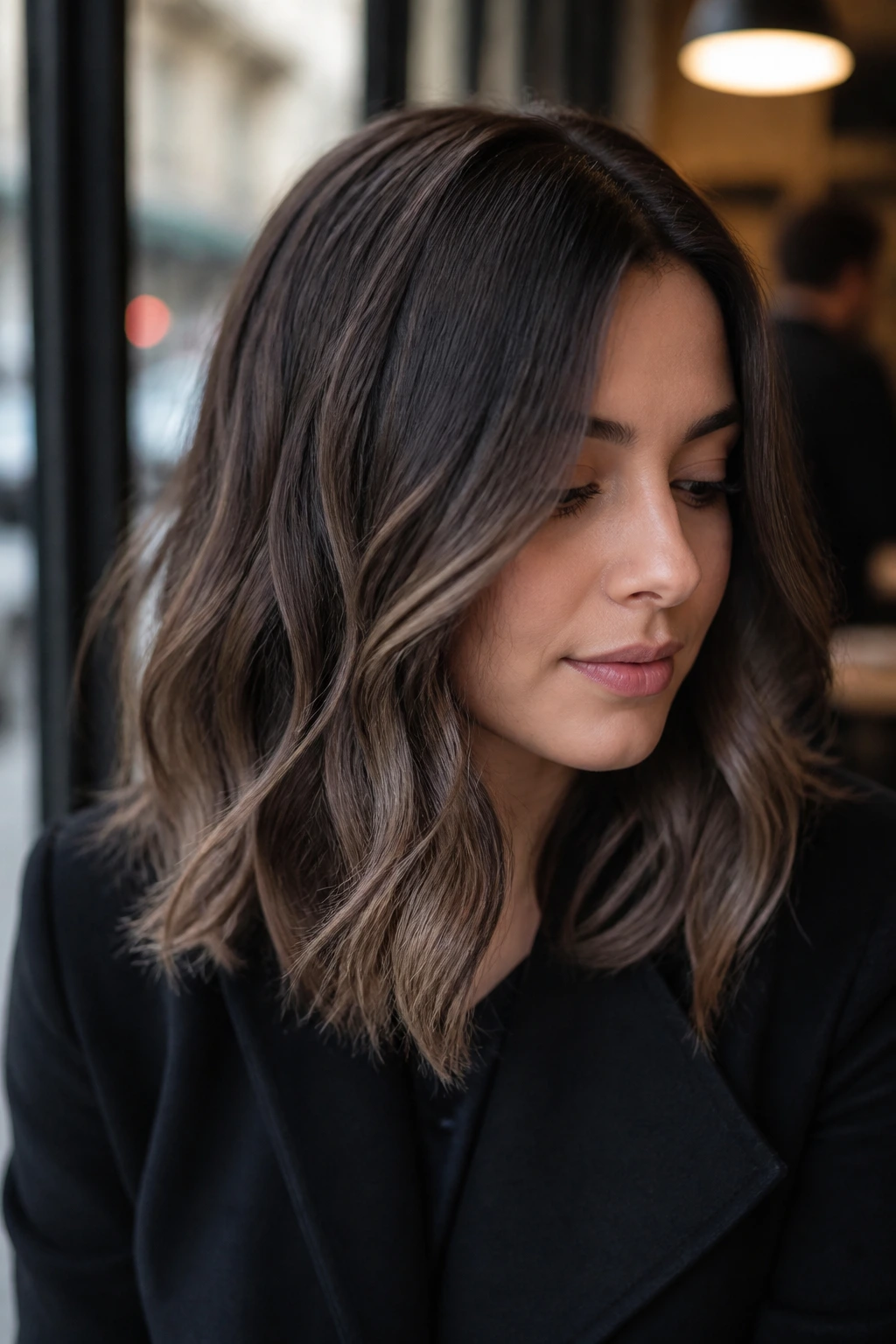 Close-up portrait of a real woman with smoky brunette hair and soft ends