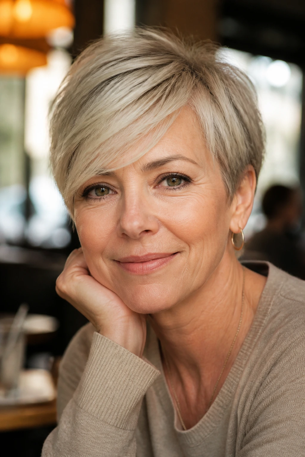 Close-up of a real woman with a soft crop and swept fringe in a cafe light