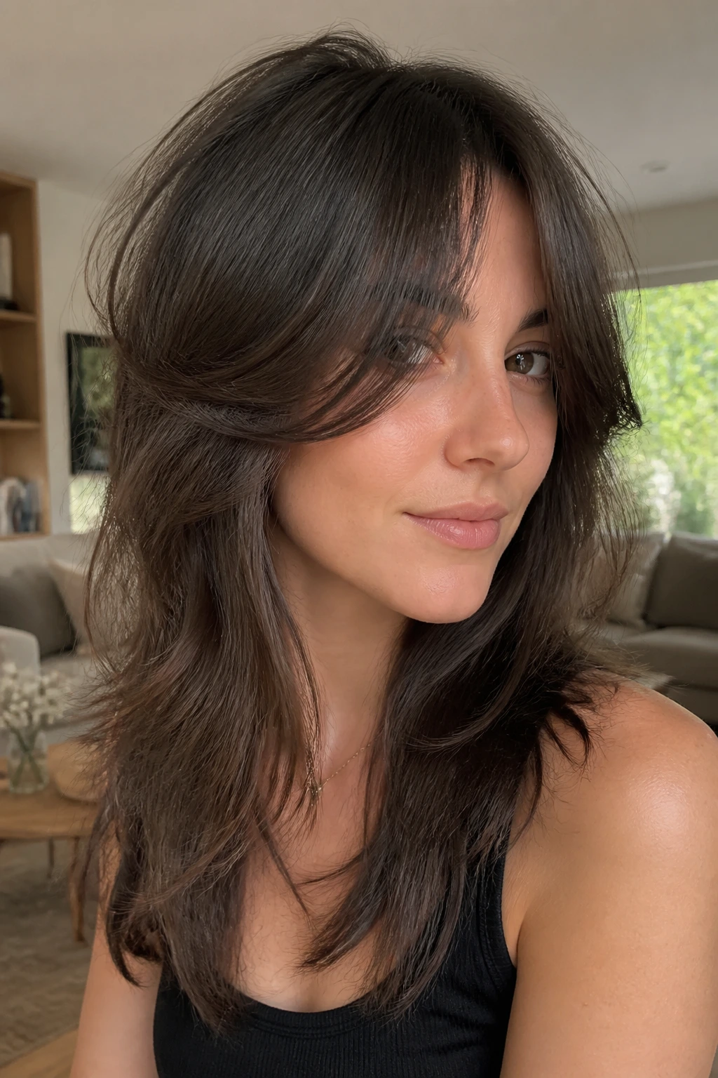 Close-up of a real person with soft feathered wolf cut and airy curtain bangs