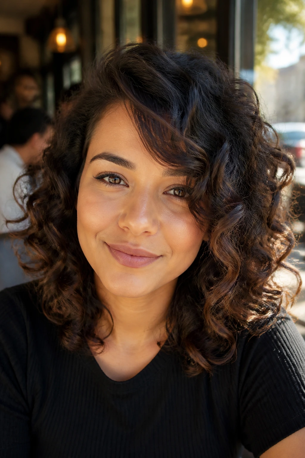 Close-up of a woman with spiral curls and a side sweep