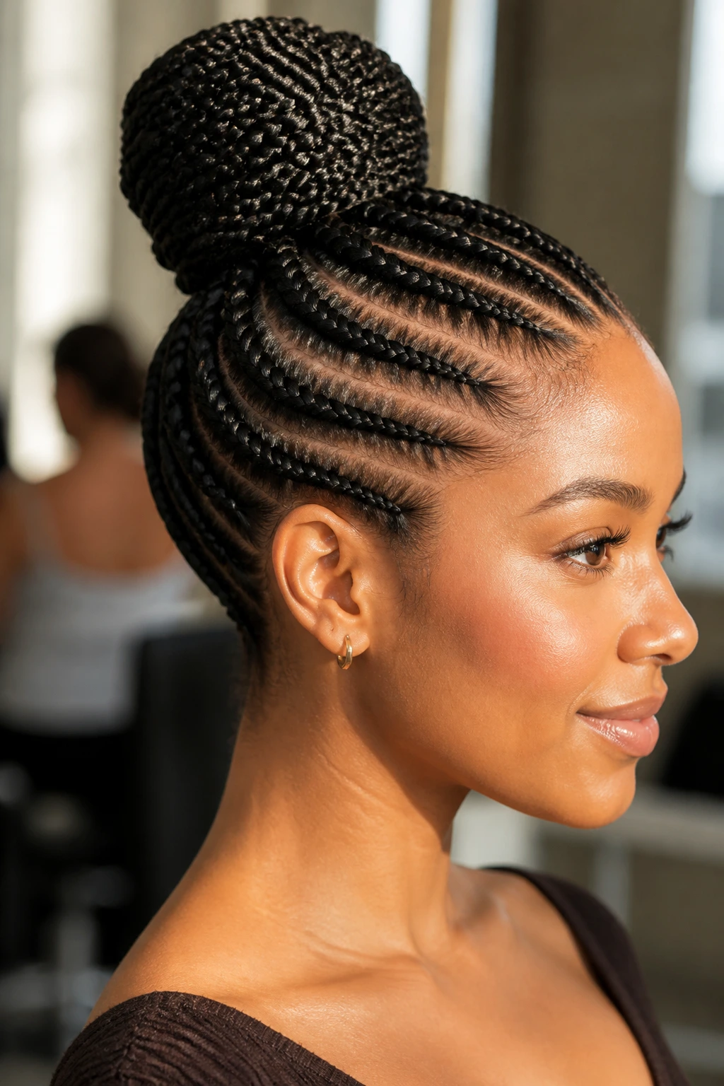 Close-up of a real woman with stitch braids forming a high bun, clean lines and bright natural light