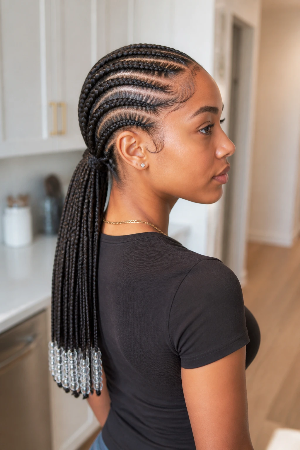 Close-up of stitch braids pulled into a low ponytail on a real person.