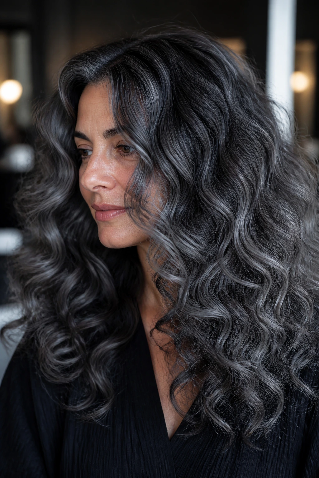 Close-up of a real woman with storm cloud balayage in moody lighting
