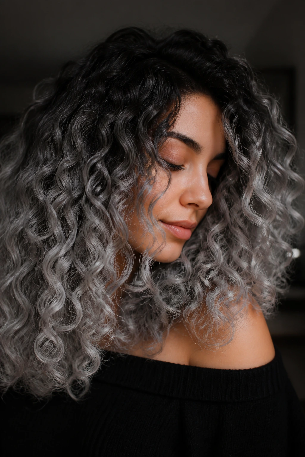 Portrait of a person with stormcloud melt hair gradient from dark roots to silver ends.