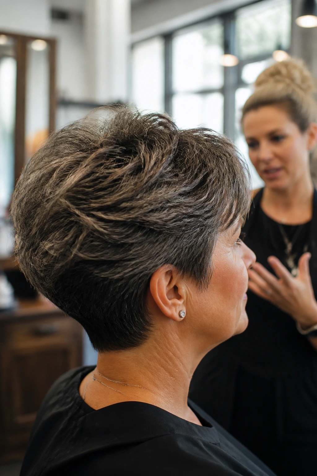 Real client in salon discussing hairstyle with stylist.