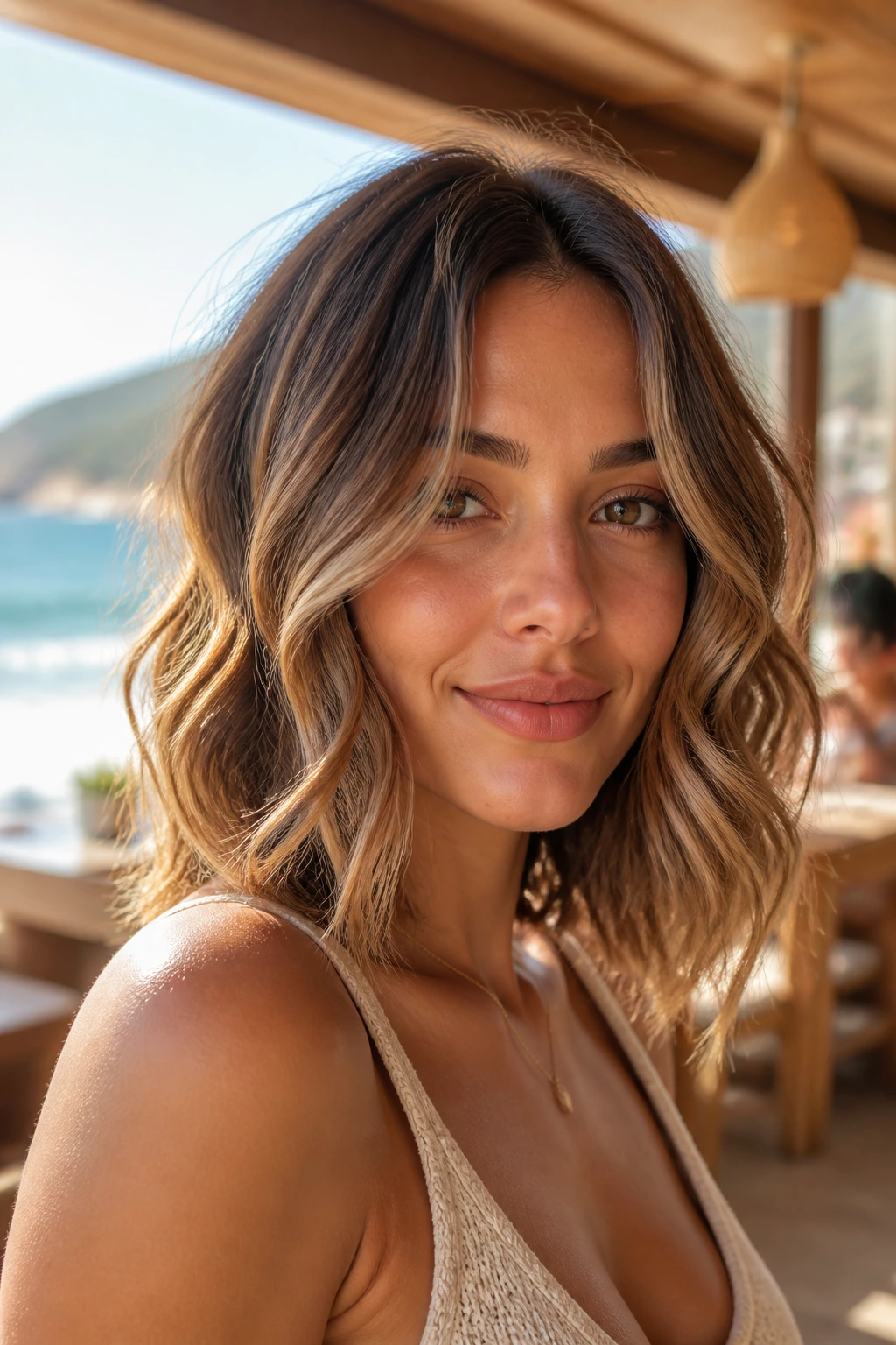 Real woman with sunlit mocha lob balayage on collarbone-length waves