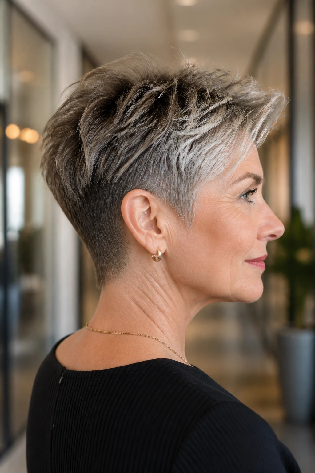 Close-up portrait of a real woman with tapered neck pixie mullet showing a crisp nape in soft natural light