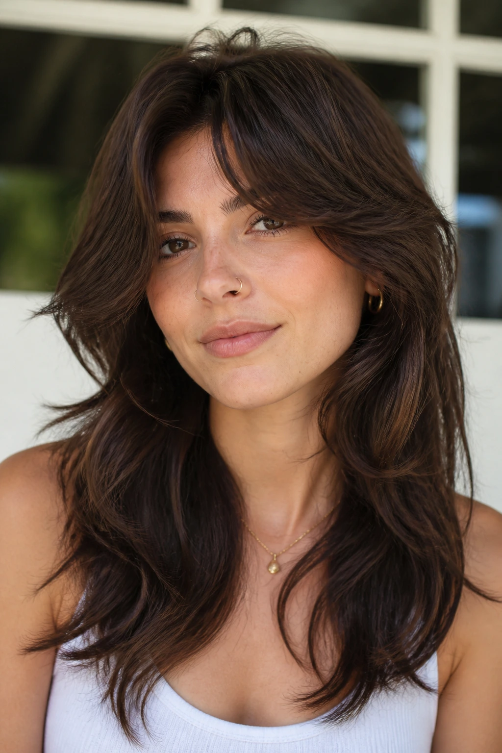 Portrait of a person with thick-hair wolf cut and feathered side bangs