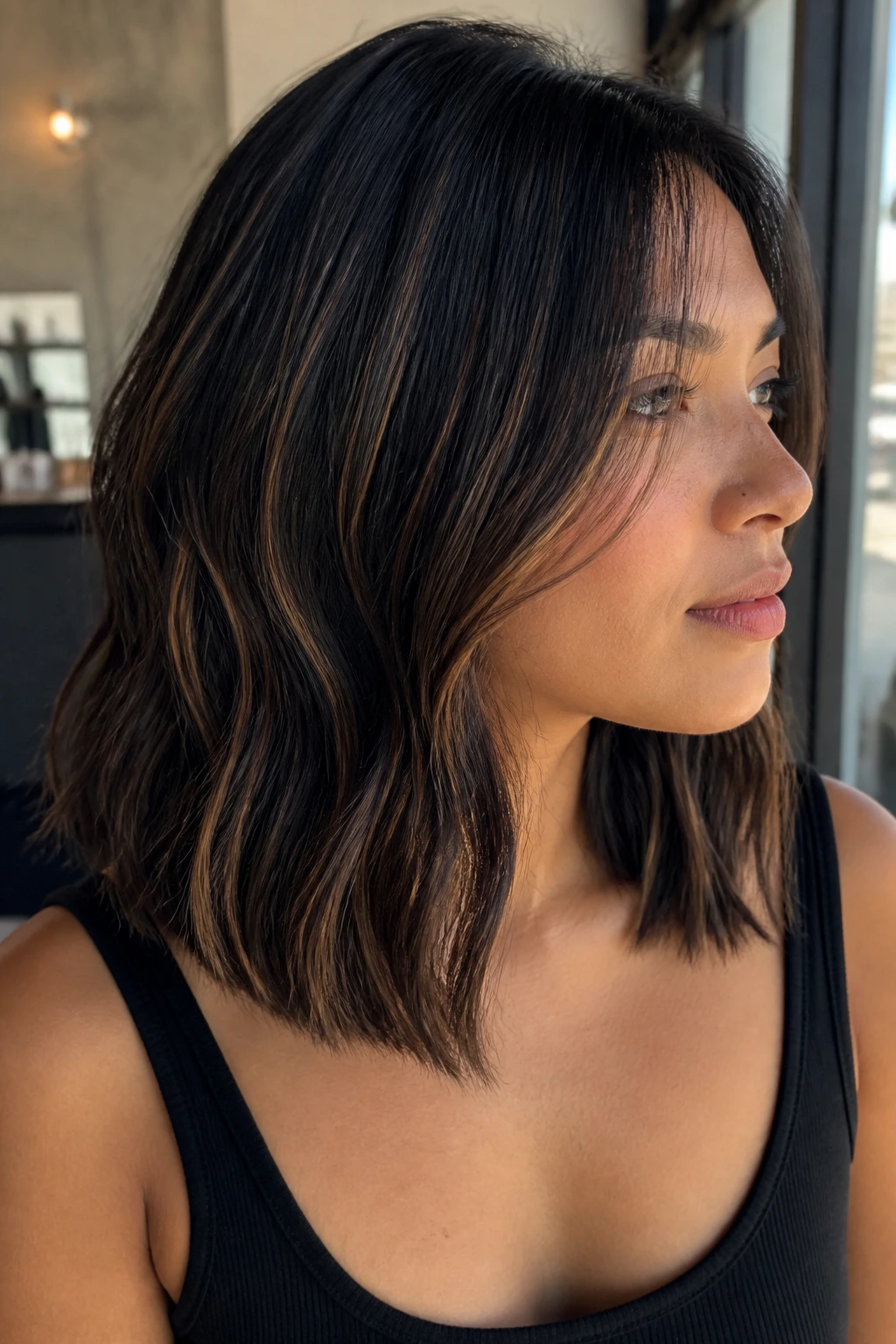 Close-up of a woman with shoulder-length black hair with tiny toffee highlights.