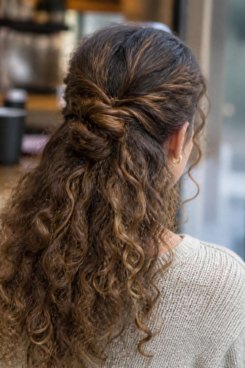 Close-up of a real woman with a twisted knot and curly ends hairstyle