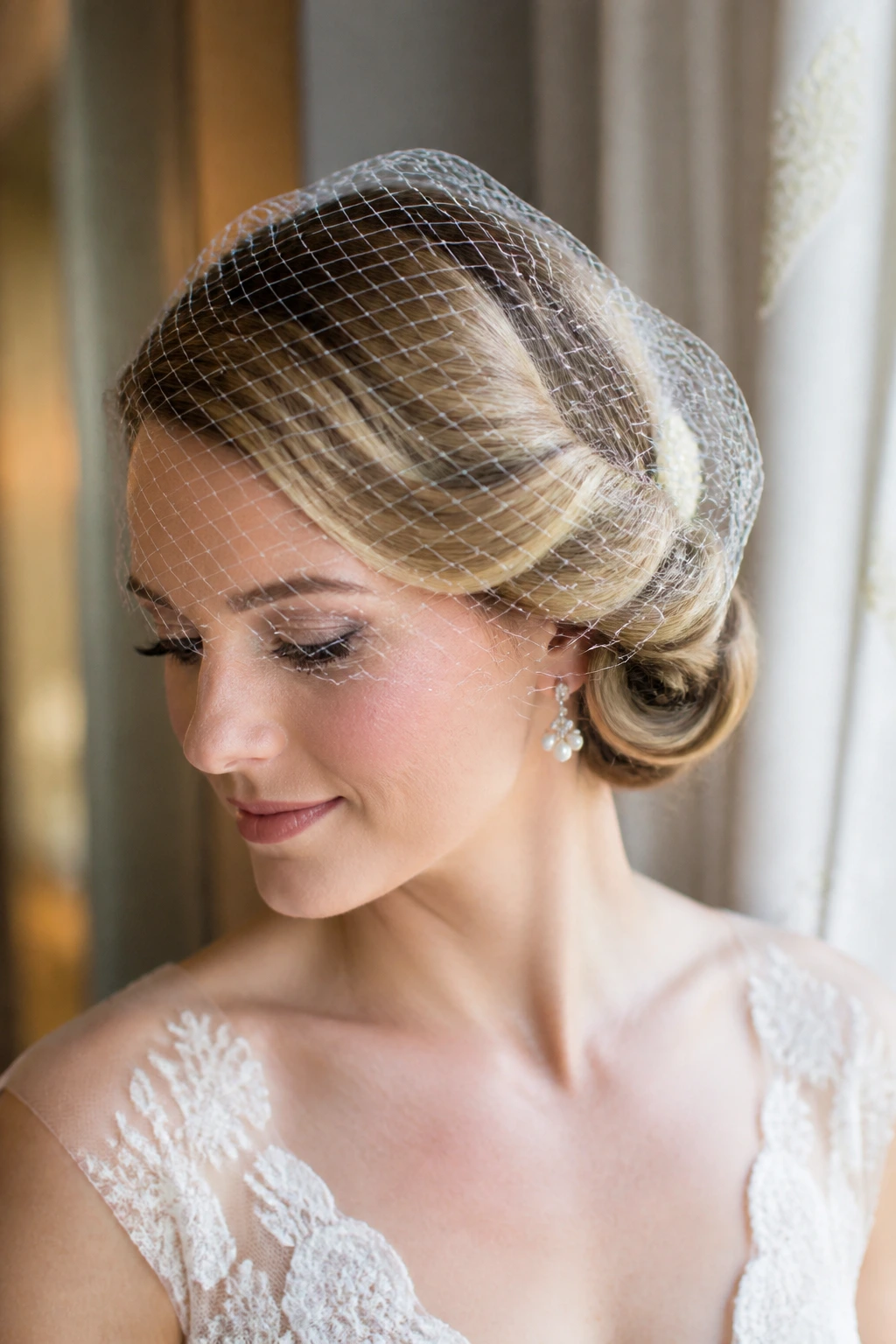 Close-up of a real bride with a twisted side roll and birdcage veil