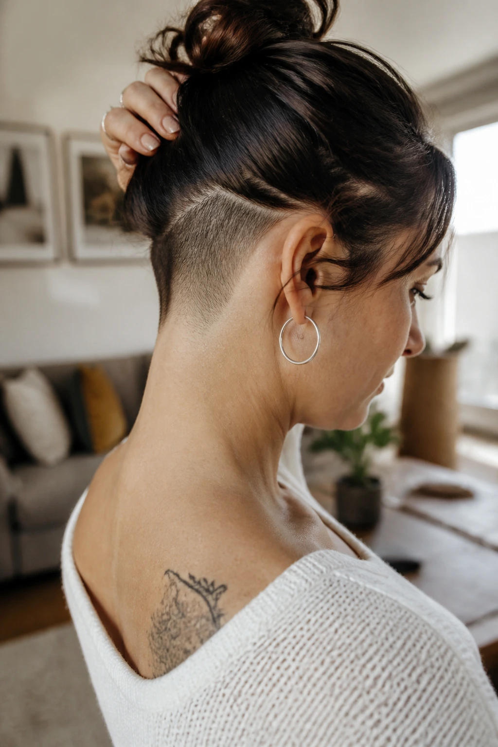 Close-up portrait of a real woman with an undercut visible at the nape when hair is up