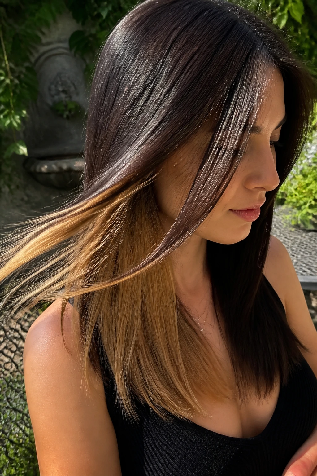 Close-up of a real woman with underlight highlights visible beneath dark top layer of straight hair