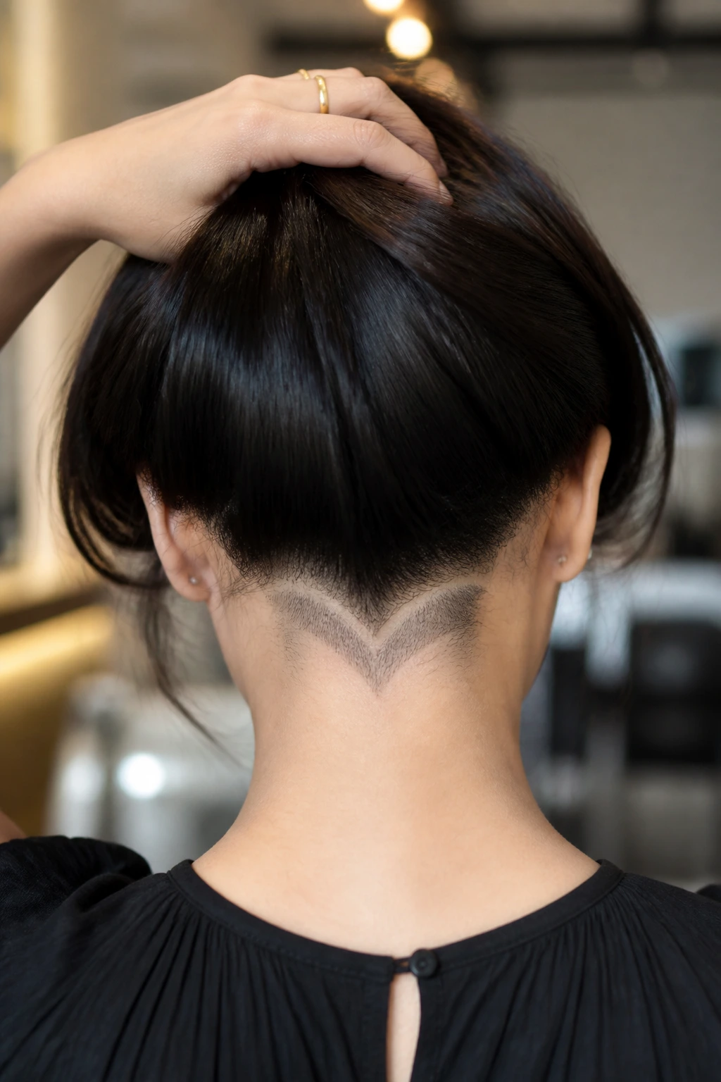 Back-of-head view of a real woman with a curved V-nape undercut.