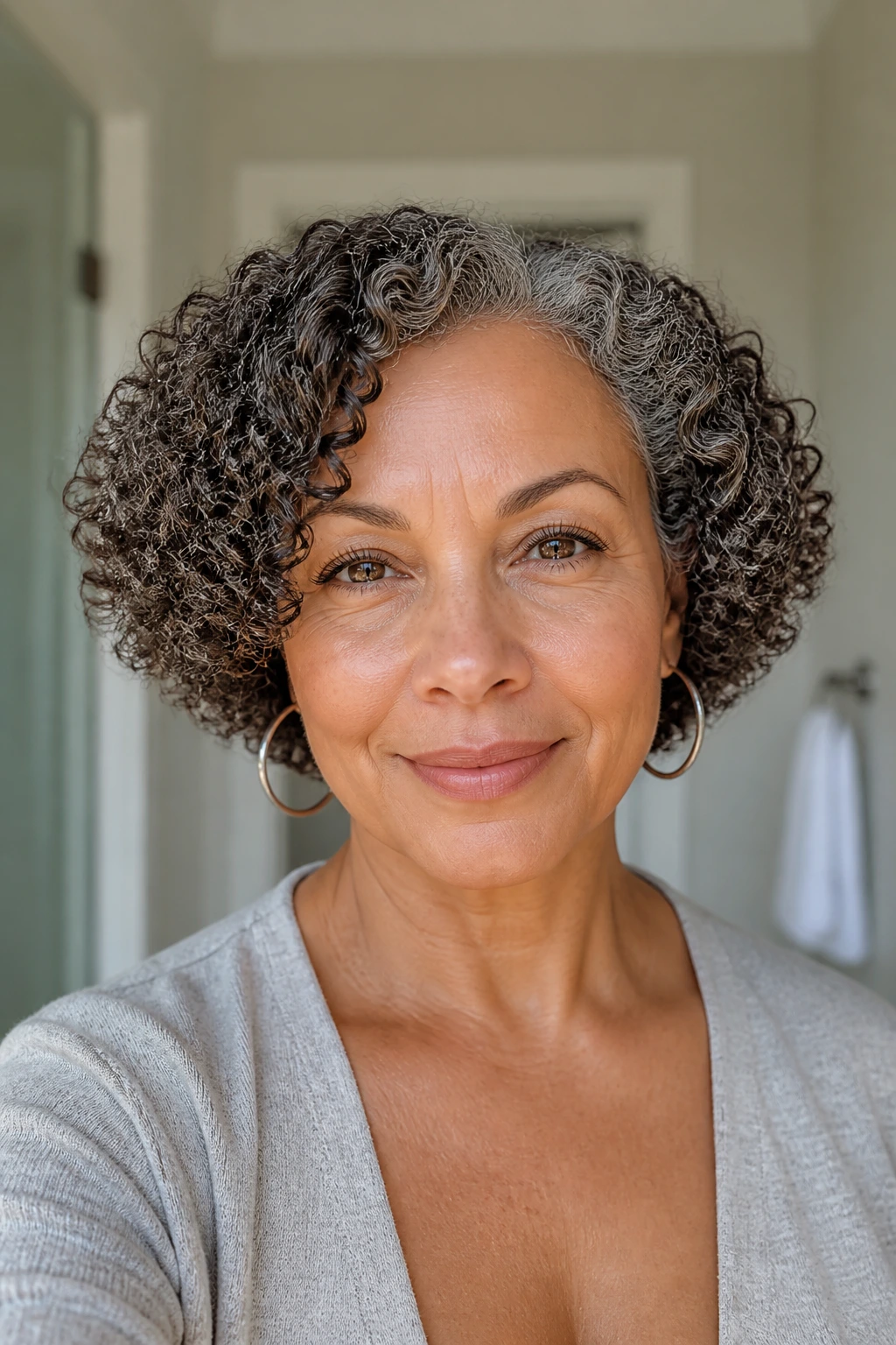 Close-up of a woman with a rounded curly bob, natural wash-and-go texture.