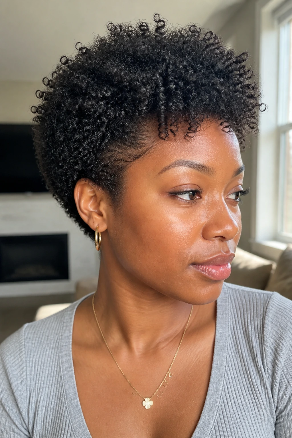 Close-up of a real person with a wash-and-go shaped cut in a bright living room.