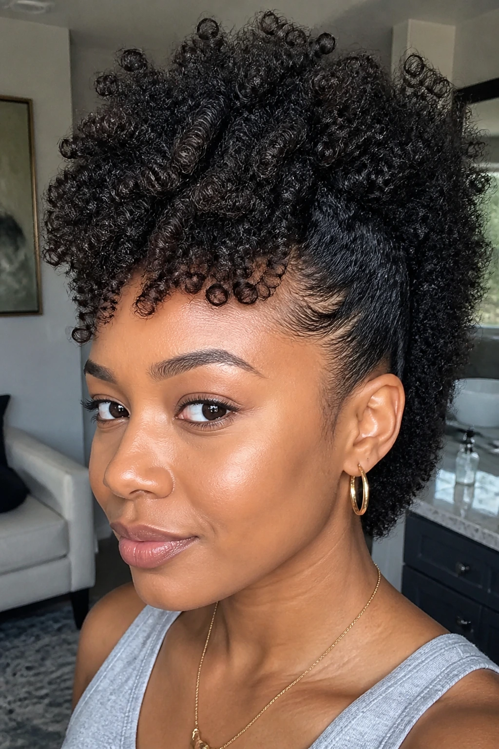 Close-up portrait of a real Black woman with a wash-and-go frohawk in a sunlit room