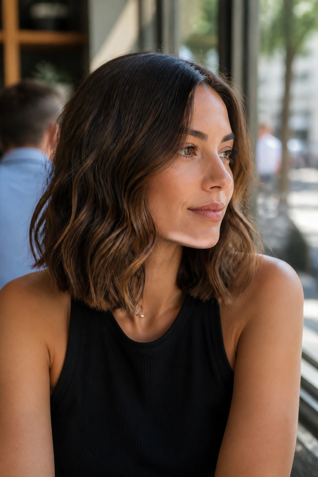 Medium close-up of a real woman with a wavy lob and blunt base