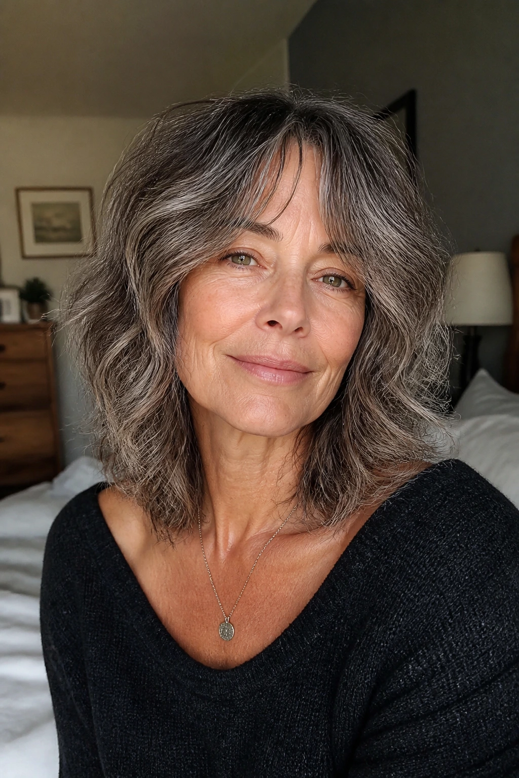 Close-up of a real woman with wavy shoulder-length midi shag and air-dried texture.