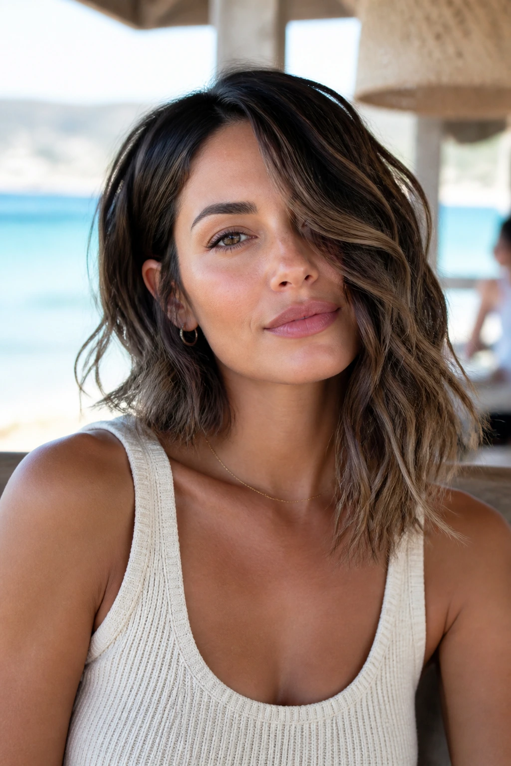 Portrait of a real woman with a wavy off-balance lob showing longer side and shorter side.
