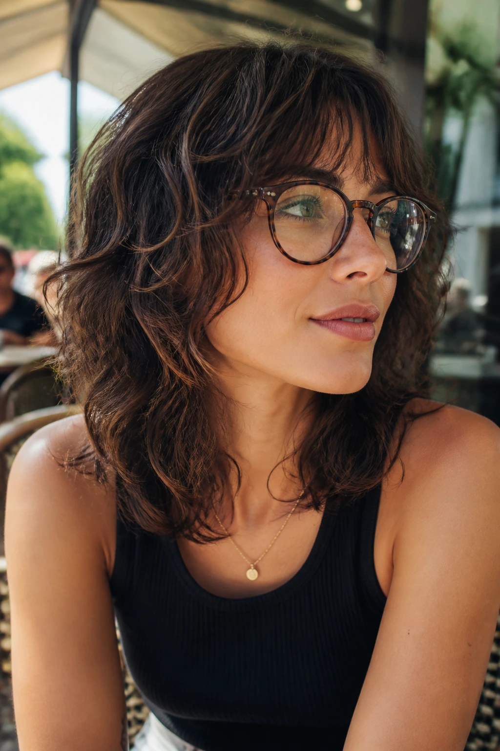 Medium close-up of a real woman with wavy shag and cheekbone-grazing pieces wearing glasses