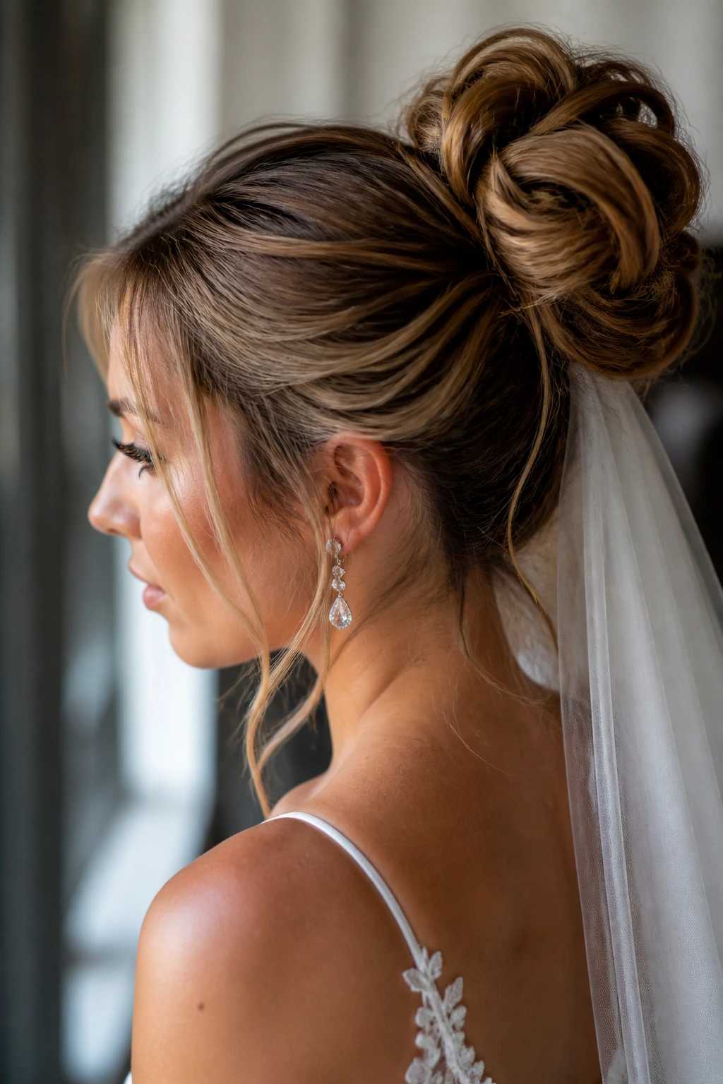 Close-up of a real bride's wedding bun hairstyle in a softly lit bridal prep room