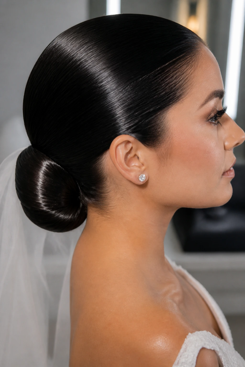Real bride with glossy wet-look bun at the nape under soft studio-like lighting