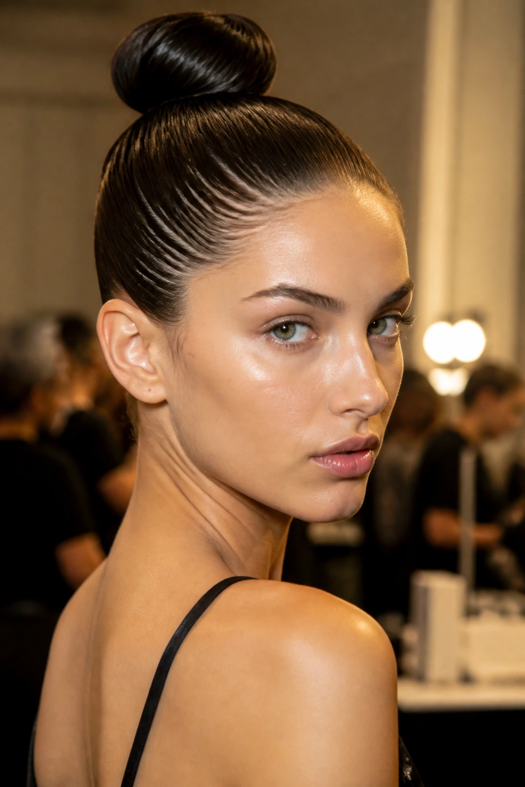 Close-up of a real woman's wet-look bun with high shine at the crown