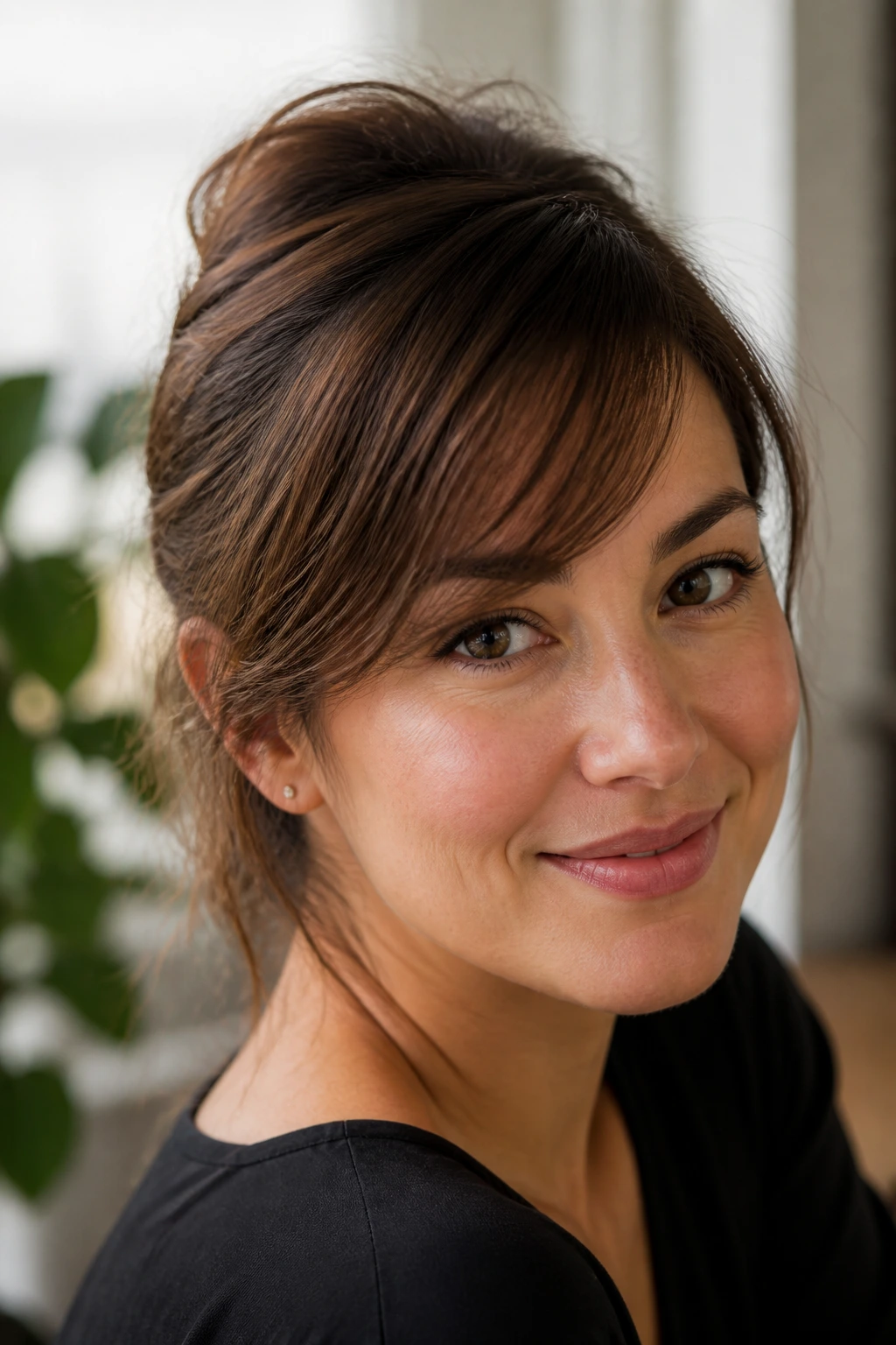 Portrait of a woman with wispy side-swept fringe across the forehead