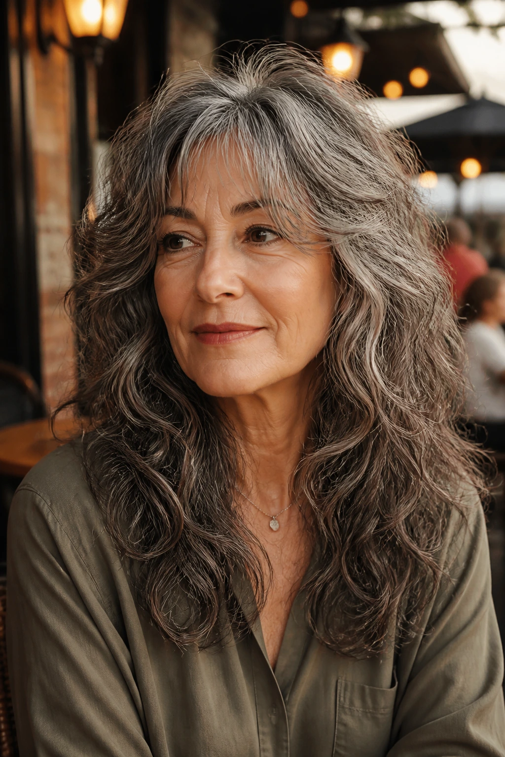 Older woman with long wolf cut and soft-edged ends in warm outdoor light.