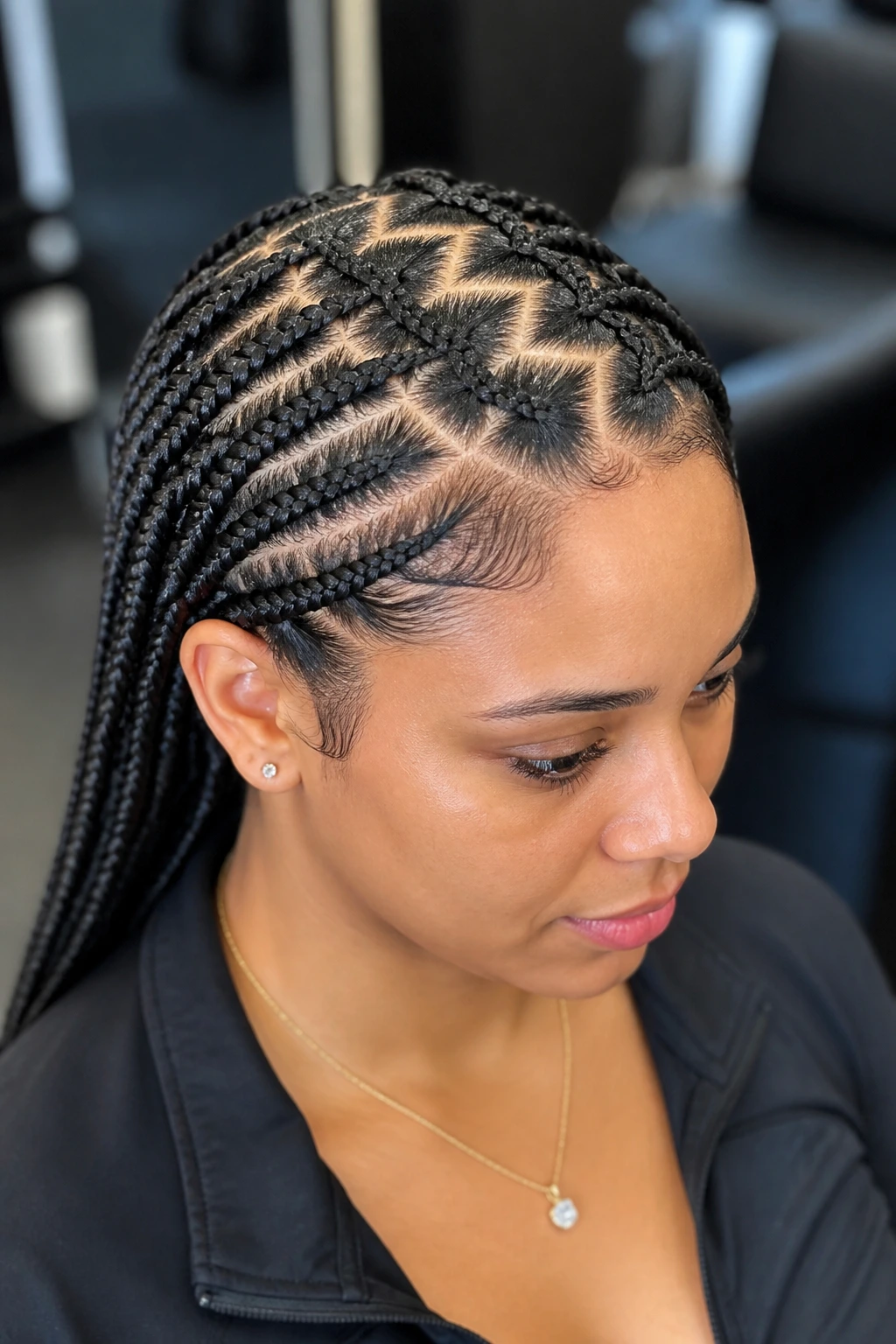Close-up of a real woman's scalp with zigzag-part braids in a salon